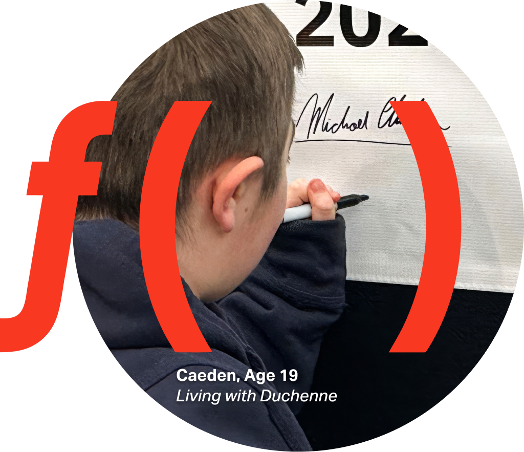 Close-up of a young man’s hand holding a black marker and writing on a white surface, with part of the side of the head visible in the foreground. A large red “f(x)” graphic is overlaid. Small text reads in the bottom left "Caden, Age 19 Living with Duchenne"